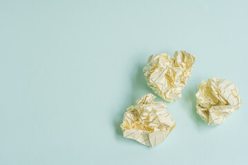 crumpled white paper ball on a light blue background