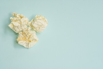 crumpled white paper ball on a light blue background
