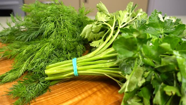 Fennel and parsley on a wooden cutting board.