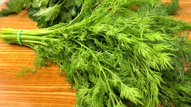 Fennel and parsley on a wooden cutting board.