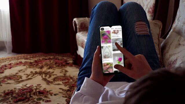 A teenager looks creative ideas on a smartphone.