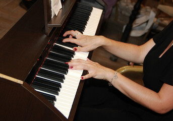 Fototapeta premium female hands play music on white and black piano keys