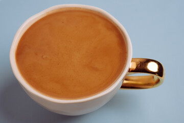 Top view to white cup with delicious coffee on smoky blue background. Greeting card. Post card. Place for your text.
