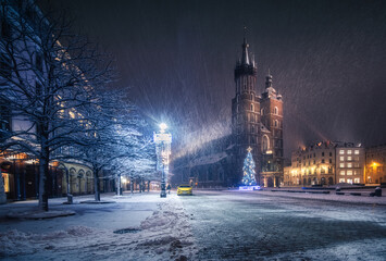 The main square in Krakow with a view of the cloth hall and St. Mary's Basilica in winter. Rynek główny w krakowie z widokiem na sukiennice, bazylikę mariacką w zimie.  - obrazy, fototapety, plakaty