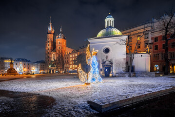 The main square in Krakow with a view of the cloth hall and St. Mary's Basilica in winter. Rynek główny w krakowie z widokiem na sukiennice, bazylikę mariacką w zimie.  - obrazy, fototapety, plakaty