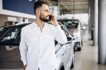 Man talking on the phone in a car showroom