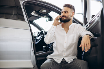 Man talking on the phone in a car showroom