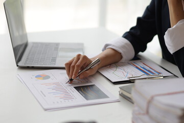 Business woman at office desk analyzing financial data and planning investment investments.