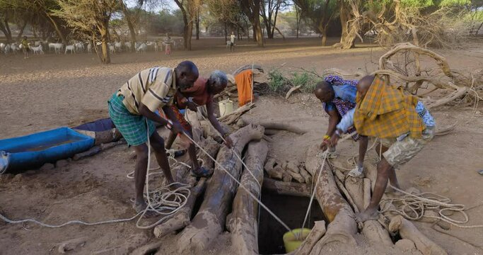 Climate change.drought.water crisis.Close-up.African men drawing water for livestock from very deep wells due to persistent drought. Kenya