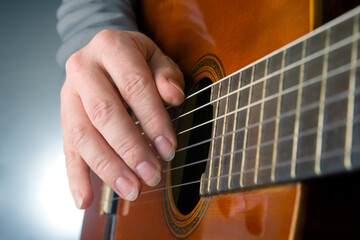man plays the classical guitar. string musical instrument. hands of the musician playing on classical guitar