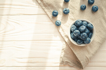 Obraz na płótnie Canvas Freshly picked juicy blueberries in the bowl on wooden background, close up. Blueberries background. Concept of healthy nutrition, organic food. Vegan and vegetarian