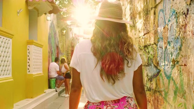 Following shot of beautiful tourist girl walking in cartagena streets.