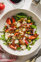 Tasty dried tomatoes salad with fresh vegetables mix and mozzarella cheese served with toasts