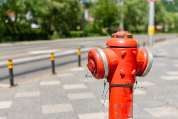 Close-up of a red hydrant plug on a sidewalk with blurred background