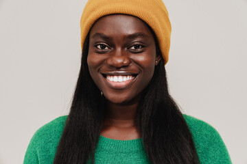 Portrait of young beautiful smiling african woman in winter hat