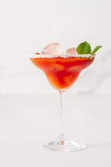 Alcoholic drink with tomato juice in a glass with ice close-up on a white background