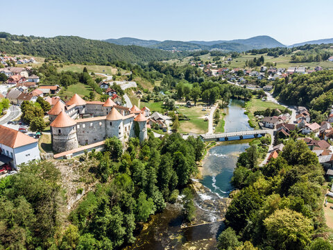 Aerial drone view of Medieval castle of Zuzemberk or Seisenburg or Sosenberch, positioned on terrace above the Krka River Canyon, Central Slovenia.