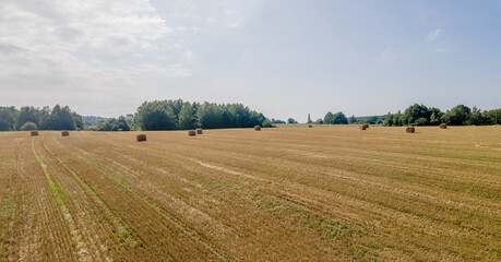 Fototapeta na wymiar Aerial view of hay bales on the field after harvest. Landscape of straw bales on agricultural field. Countryside landscape.
