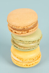 Cake macaron or macaroon on turquoise background from above, colorful almond cookies, pastel colors, vintage card