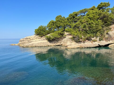 Sea bay with blue turquoise water and pine rocky island.