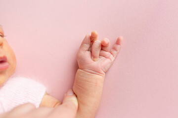 hands of a newborn baby. small children's hand on a pink background
