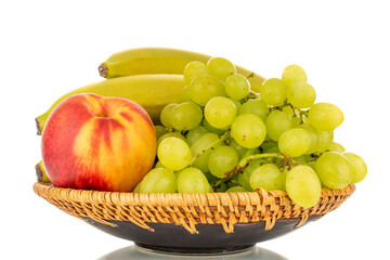 One bunch of white grapes Quiche mish, bananas and nectarine on a ceramic plate, close-up, isolated on a white background.