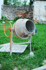 Concrete mixer on a green grassy lawn. Construction, repair.