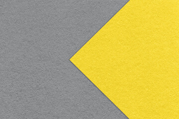 Fototapeta na wymiar Texture of paper gray background, half two colors with yellow arrow, macro. Structure of dense craft cardboard