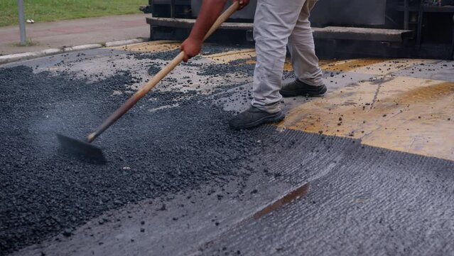 Fresh asphalt road with workers and paving machines, road construction process