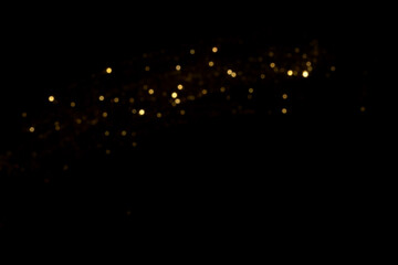 Golden blurred bokeh lights on black background. Glitter sparkle stars for celebrate. Overlay for...