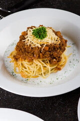 Traditional italian pasta spaghetti with bolognese meat sauce and parmesan on texture table. Close up