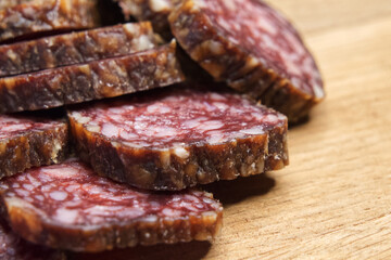 Closeup shot of sliced salami on the table. Pieces of delicious smoked sausage on a cutting board.