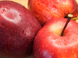 Three big red apples, closeup shot. Appetizing ripe fruits, macro.