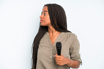 black pretty woman on profile view thinking, imagining or daydreaming. singer with a microphone
