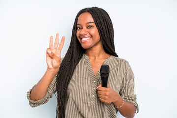 black pretty woman smiling and looking friendly, showing number three. singer with a microphone