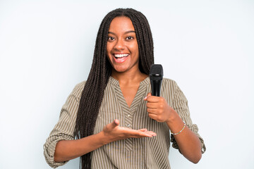 black pretty woman smiling cheerfully, feeling happy and showing a concept. singer with a microphone