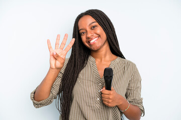 black pretty woman smiling and looking friendly, showing number four. singer with a microphone