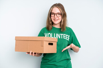 caucasian pretty woman smiling cheerfully, feeling happy and pointing to the side. volunteer and...