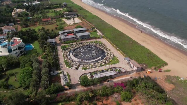 Drone footage over an Indian town Chennai with residential buildings and green trees near the ocean