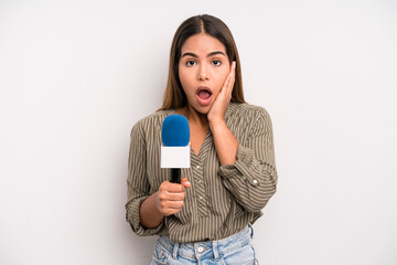 hispanic pretty woman feeling shocked and scared. presenter with a microphone concept