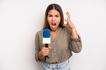 hispanic pretty woman screaming with hands up in the air. presenter with a microphone concept