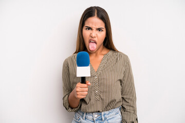 hispanic pretty woman feeling disgusted and irritated and tongue out. presenter with a microphone...