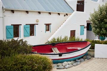 White house building with a colorful boat at the entrance in Paternoster, Western Cape, South Africa
