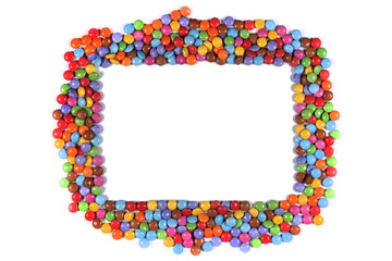 Frame border of multi coloured halloween candy sweets on white