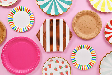 Different colorful paper party plates on pink background