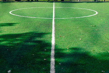 The middle of the soccer field with markings. Soccer field with markings on green grass