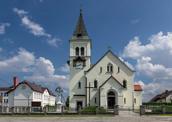 Fototapeta na wymiar Roman Catholic Church of St. Bartholomew in Hażlach against the background of a blue sky and clouds 