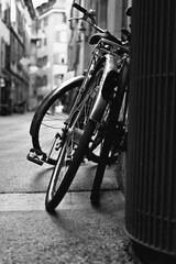 Vertical grayscale shot of a bicycle leaned on the building