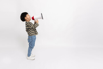 Side of Asian little boy standing and holding megaphone isolated on white background, Speech and announce concept, 5 years old