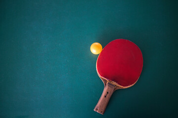 Table tennis rackets and table tennis balls on a table tennis practice table that has been used hard by training.